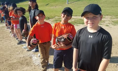 Youth posing with the equipment they received from participating in the Cal Ripken, Sr. Foundation Instructional Leagues